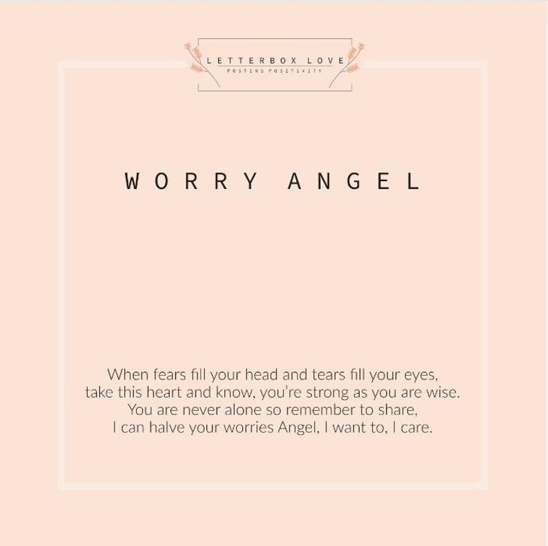 May include: A light peach-colored card with the words "WORRY ANGEL" in black. The card also includes the text "LETTERBOX LOVE POSTING POSITIVITY" and a poem about strength and sharing worries.