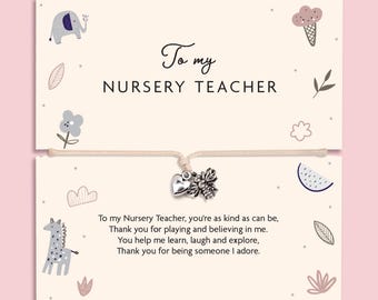 May include: A beige card featuring the text To my NURSERY TEACHER and a poem, decorated with illustrations of an elephant, ice cream, flowers, and a giraffe. A string bracelet with a silver-toned heart charm and a bee charm is attached.
