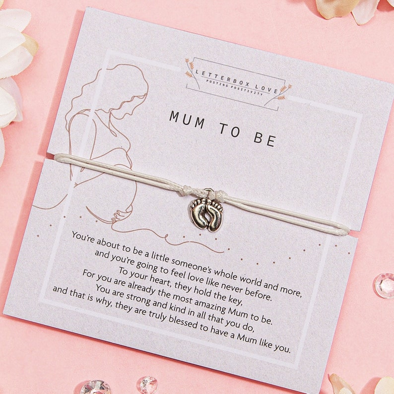 Expectant mother silhouette on 'Mum to Be' card with a heartfelt poem, featuring a delicate bracelet with a heart-shaped baby feet charm, symbolizing the new journey into motherhood.