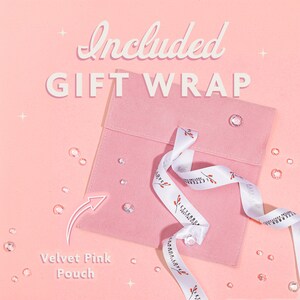 May include: A pink velvet pouch with a white ribbon featuring a floral design. The words "Included GIFT WRAP" are at the top, and "Velvet Pink Pouch" is at the bottom. Clear, sparkling embellishments are scattered around the pouch.