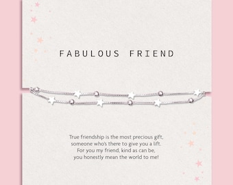 May include: A silver-toned double-strand bracelet featuring alternating small star charms and round beads, presented on a white card printed with the text FABULOUS FRIEND and a poem about friendship, decorated with small pink star illustrations.