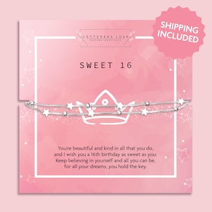 May include: A silver-toned double-strand bracelet featuring small star and bead charms, presented on a pink card with the text SWEET 16 and a printed crown graphic. The card includes a message about a 16th birthday and believing in oneself.