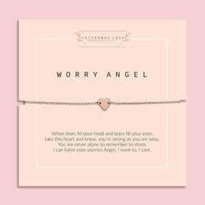 Delicate gold chain bracelet with a small heart charm displayed on a pale peach card. The card reads 'Worry Angel' at the top, with a poem below: 'When fears fill your head and tears fill your eyes, take this heart and know, you’re strong as you are wise. You are never alone so remember to share, I can halve your worries Angel, I want to, I care.' The brand name 'Letterbox Love' appears at the top with the tagline 'Posting Positivity'.
