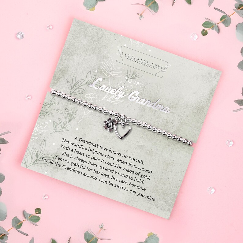 Silver beaded bracelet with heart and flower charms presented on a “To My Lovely Grandma” poem card, displayed in soft pink and green tones. A sentimental silver bracelet gift for Grandma or Nan, perfect for birthdays, Christmas, or family occasions.