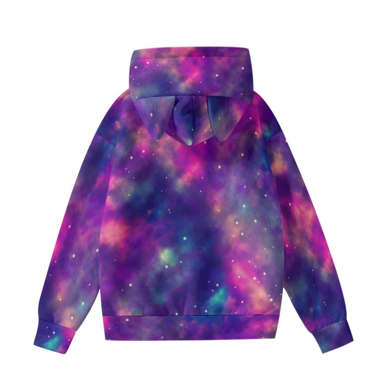 May include: A hooded sweatshirt with a galaxy print in shades of purple, pink, and blue. The hoodie features a unique design with pointed ears on the hood. The sleeves and body of the sweatshirt are visible.