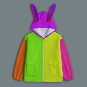 Könnte beinhalten: Ein buntes Kapuzen-Sweatshirt mit Reißverschluss und Hasenohren-Kapuze. Das Sweatshirt hat ein Colorblock-Design mit orangefarbenen, grünen, gelben und pinkfarbenen Einsätzen. Die Kapuze ist lila mit roten und lila Ohren. Zwei Taschen sind sichtbar.