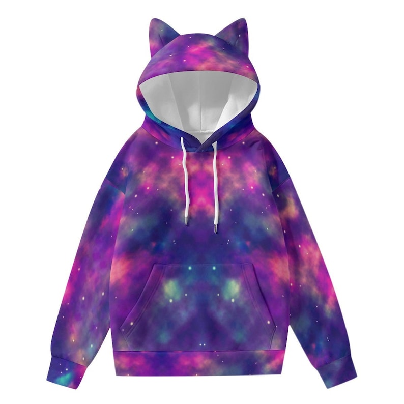 May include: A hooded sweatshirt with a galaxy print in shades of purple, pink, and blue. The hoodie features cat ears on the hood and a front pocket. White drawstrings are visible at the neckline.