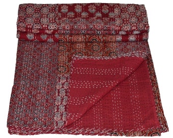 Op de afbeelding: Een rode kantha-deken met een patchwork-ontwerp met ingewikkelde bloem- en geometrische patronen. De deken is gemaakt van katoen en heeft een handgestikte uitstraling.