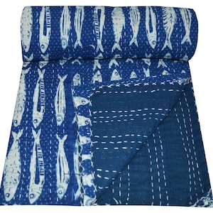 Könnte beinhalten: Eine blau-weiße Steppdecke mit Fischmuster. Die Decke hat ein sich wiederholendes Design aus weißen Fischen auf blauem Hintergrund. Sie besteht aus weichem Stoff und hat weiße Nähte. Die Decke ist gefaltet.