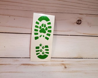 May include: Green vinyl decal of a shoe print with paw prints inside. The decal is on a white background.
