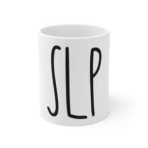 May include: White ceramic mug with the word "SLP" written in black cursive.
