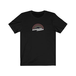 Op de afbeelding: Zwart T-shirt met een regenbooggrafiek en de tekst "Kindness counts" in wit.