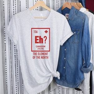 May include: A gray t-shirt with a red graphic of a Canadian flag and the text "Eh? Canadium [18.670] The Element of the North".