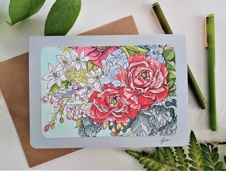 May include: A greeting card with a floral design featuring a bouquet of pink, red, white, and blue flowers on a light blue background. The card is gray with a white border.