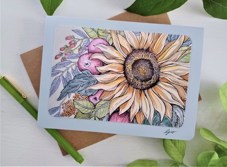 May include: A light blue card with a watercolor illustration of a sunflower with pink and yellow berries. The sunflower is in the center of the card and is surrounded by leaves and berries. The card is signed "Gin" in the bottom right corner.
