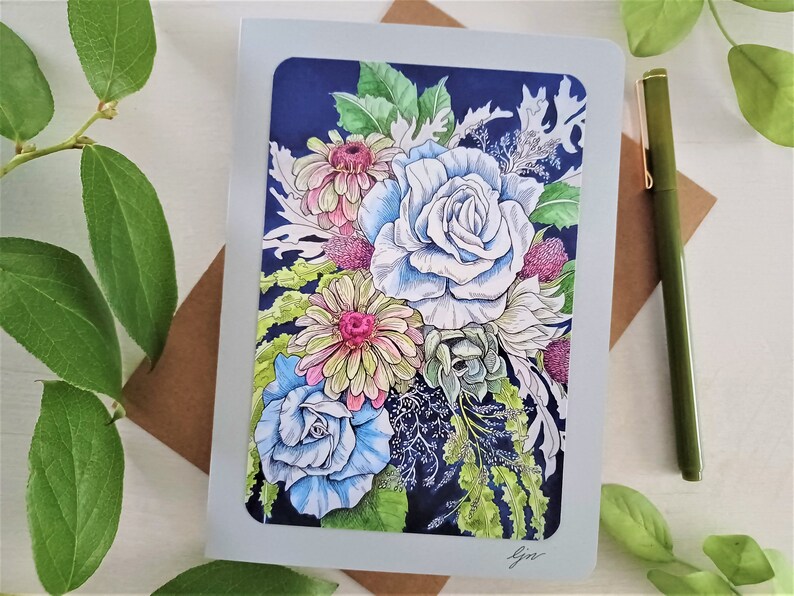 May include: A greeting card featuring a colorful floral bouquet with blue, pink, and yellow flowers on a dark blue background. The card is signed "gin".