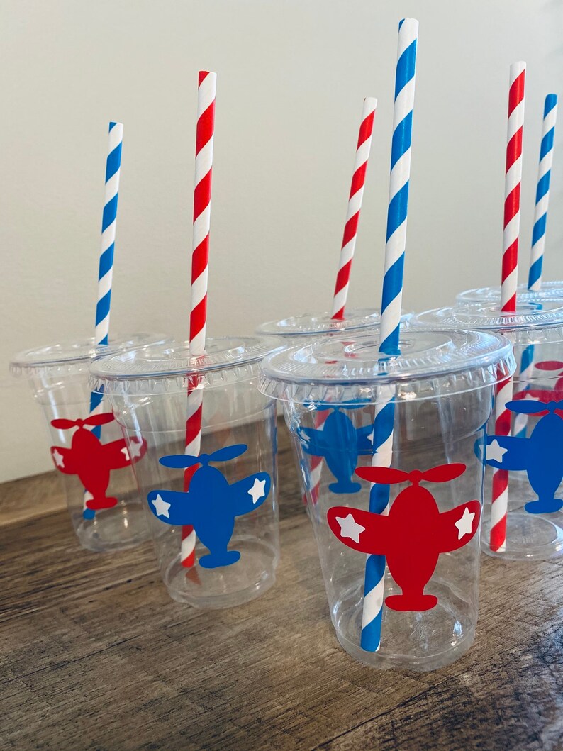 May include: Clear plastic cups with red and blue airplane designs and red and blue striped straws.