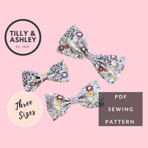 May include: Three sizes of floral bow tie sewing patterns. The patterns are in PDF format. The bow ties are white with a floral print in shades of purple, orange, and green.