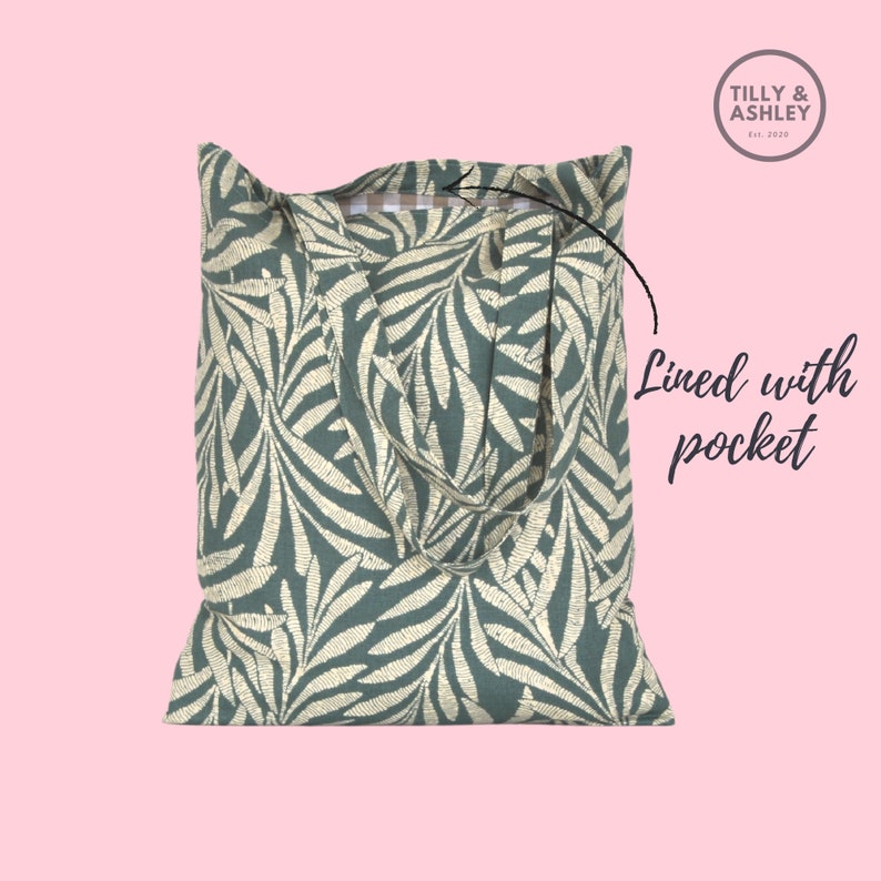 May include: A green and white floral tote bag with a pocket. The bag has two long straps and a checkered lining.