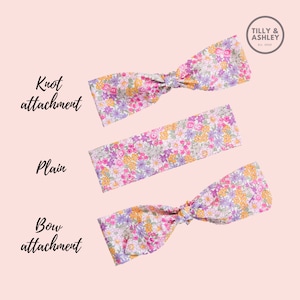 Puede incluir: Tres diademas de estampado floral con diferentes estilos de sujeci&oacute;n: nudo, liso y lazo. Las diademas son todas rosas con flores moradas, amarillas y blancas.