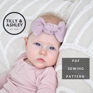 May include: A PDF sewing pattern for a baby headband with a large, knotted bow. The headband is a light purple color and is shown on a baby wearing a pink outfit. The pattern is from Tilly & Ashley, Est. 2020.