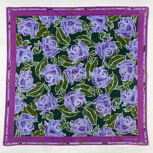 May include: Square scarf with a floral design. The scarf has a dark green background with a repeating pattern of purple roses and green leaves. A purple border frames the design. The word "GIVENCHY" is visible in the corner.