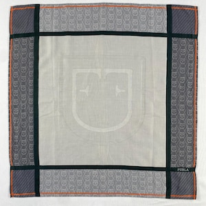 May include: Square scarf with a repeating pattern of a stylized cat face in grey and white. The scarf has a grey border with orange and black accents. The centre features a large, light grey emblem. The word "FURLA" is printed in the bottom right corner.