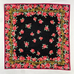 Peut inclure: Foulard carré noir avec une bordure rose, orné d'un motif de roses rouges et de maillons de chaîne dorés. Le centre présente des roses éparses. Le foulard a une bordure rose et le mot "GIVENCHY" est visible dans le coin.