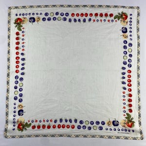 May include: White square scarf with a border of red, blue, and green fruits and vegetables. The border is framed by a plaid pattern. The scarf has the word "BURBERRY" printed in the bottom right corner.