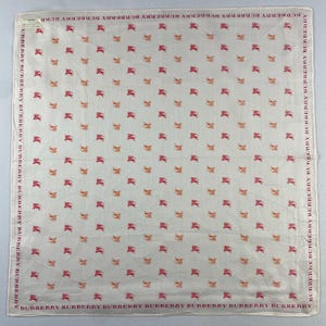 May include: Square white scarf with a repeating pattern of red and orange horse-like figures. The border features the text "BURBERRY" in red. A classic accessory.