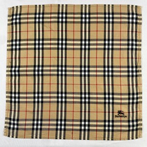 May include: A square handkerchief with a tan, black, white, and red plaid pattern. The Burberrys logo is visible in the bottom right corner. The design consists of intersecting lines, forming a grid. The fabric is likely cotton.