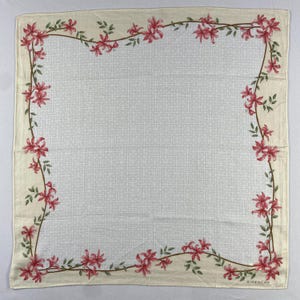 May include: Square cream scarf with a floral border. The border has pink flowers and green leaves on brown stems. The centre has a repeating pattern. The word "GIVENCHY" is printed in the bottom right corner.