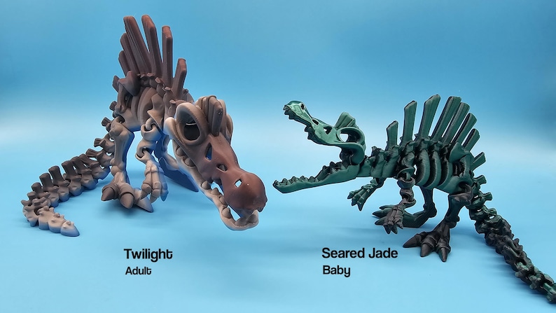 Pu&ograve; includere: Due scheletri di dinosauro di plastica, uno adulto e uno bambino. L'adulto &egrave; di colore marrone e blu ed &egrave; etichettato "Twilight Adult". Il bambino &egrave; verde ed &egrave; etichettato "Seared Jade Baby".