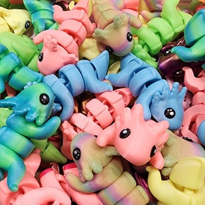 May include: A collection of colourful, bendable, plastic toys shaped like dragons. The toys are in various shades of blue, green, pink, yellow, and purple.