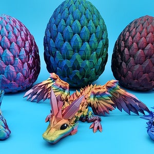 May include: Three dragon eggs, one green, one purple, and one red, with two rainbow-colored dragon figurines. The dragon figurines are made of a 3D printed material and have a detailed, scaly texture.