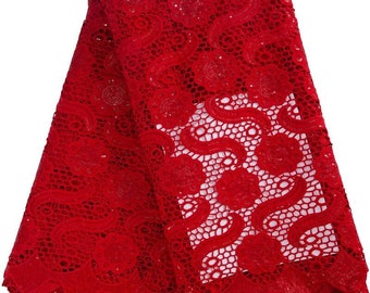 May include: Red lace fabric with a delicate floral pattern and sequins. The lace has a scalloped edge.