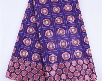 May include: Purple and pink cotton lace fabric with a floral pattern. The fabric has a scalloped edge and a border of pink circles.