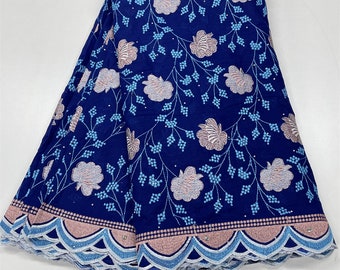 May include: Blue cotton fabric with a floral pattern in pink and light blue. The fabric has a scalloped edge with a light blue and pink trim.