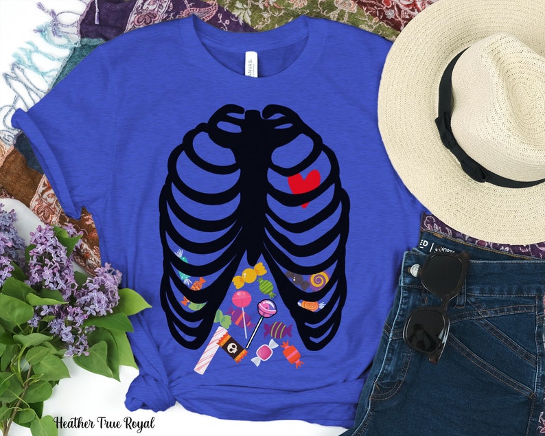 May include: A royal blue t-shirt with a black skeleton outline filled with colorful candy. The skeleton has a red heart in the center of its chest.