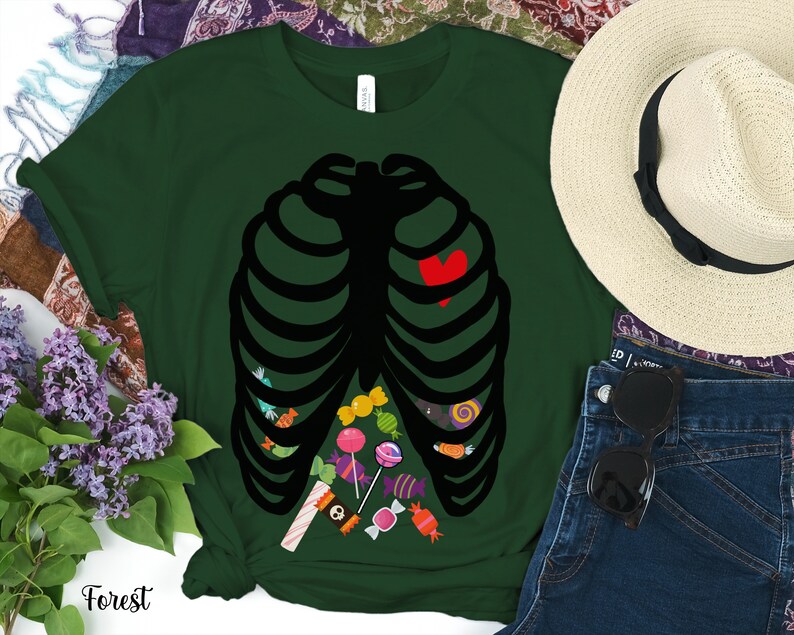 May include: A dark green t-shirt with a black skeleton ribcage design. The ribcage is filled with colorful candy and a red heart. The shirt is a fun and festive Halloween costume.