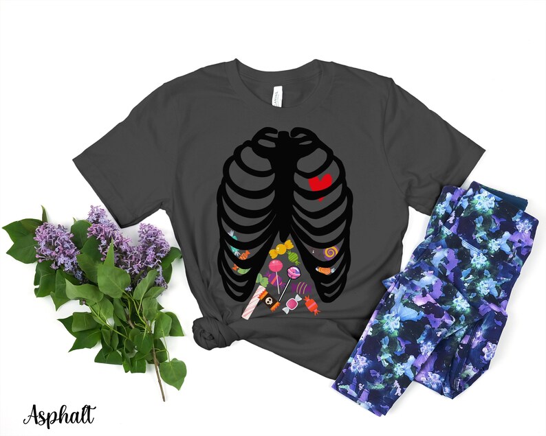May include: A dark gray t-shirt with a black skeleton outline filled with colorful candy. The skeleton has a red heart in the center of its chest.