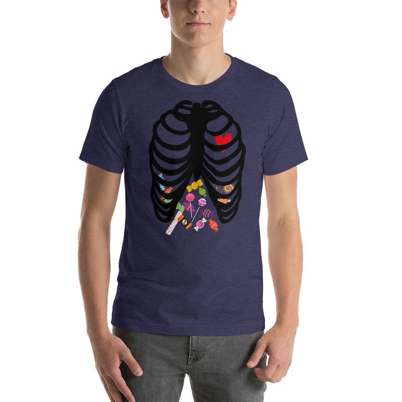 May include: A navy blue t-shirt with a black skeleton ribcage design. The ribcage is filled with colorful candy, including lollipops, candy canes, and gummy worms. A red heart is in the center of the ribcage.