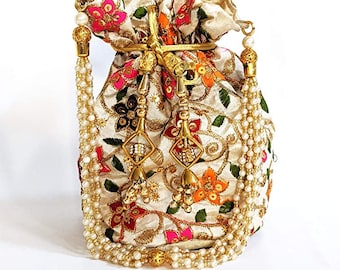 May include: Ivory drawstring bag with intricate floral embroidery in pink, orange, and green. The bag features gold accents, beaded tassels, and pearl-like strands. A decorative and ornate accessory.