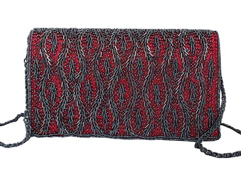 May include: A rectangular red evening bag with a beaded design. The bag is covered in small, dark gray beads arranged in a chevron pattern. It has a matching beaded strap.