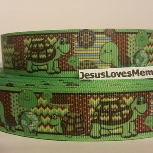 May include: Green and brown ribbon with a repeating pattern of cartoon turtles. The ribbon has a patchwork design with different colored stripes and polka dots.