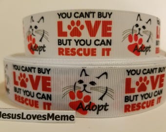 Peut inclure: Ruban blanc avec une empreinte de patte rouge et le texte "You can't buy love but you can rescue it" et une illustration de chat noir et blanc. Le ruban dit aussi "Adopt" en rouge.