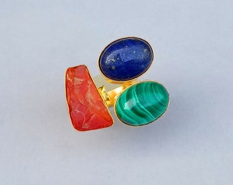 May include: A gold ring with three gemstones: a red carnelian, a blue lapis lazuli, and a green malachite.