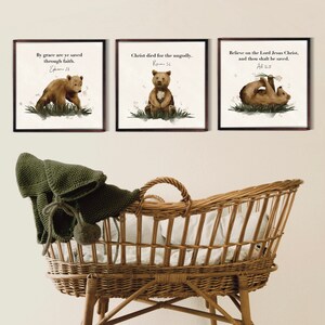 May include: Three framed prints with watercolor illustrations of brown bears and inspirational quotes. The quotes are "By grace are ye saved through faith. Ephesians 2:8", "Christ died for the ungodly. Romans 5:6", and "Believe on the Lord Jesus Christ, and thou shalt be saved. Acts 16:31".