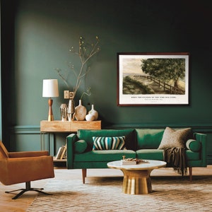 May include: A green velvet sofa with a brown throw blanket sits in a living room with a wooden console table and a gold lamp. A framed watercolor painting of a path through a forest hangs on the wall above the sofa. The painting includes the text "When the fullness of the time was come."