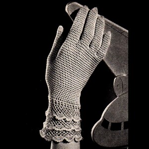 May include: A vintage, off-white crochet glove with a delicate, openwork design. The glove features a scalloped, ruffled edge at the wrist. The image is set against a dark background, highlighting the intricate details of the handmade accessory.